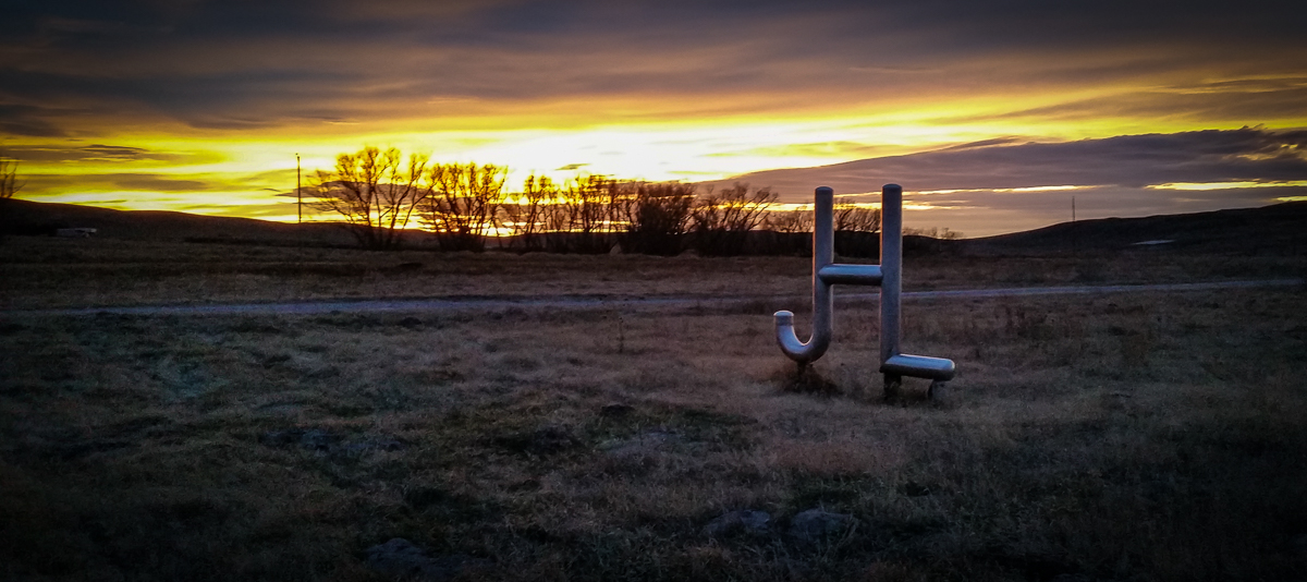 JHL brand sign at The Main Place entrance with winter sunset and Cottonwood trees